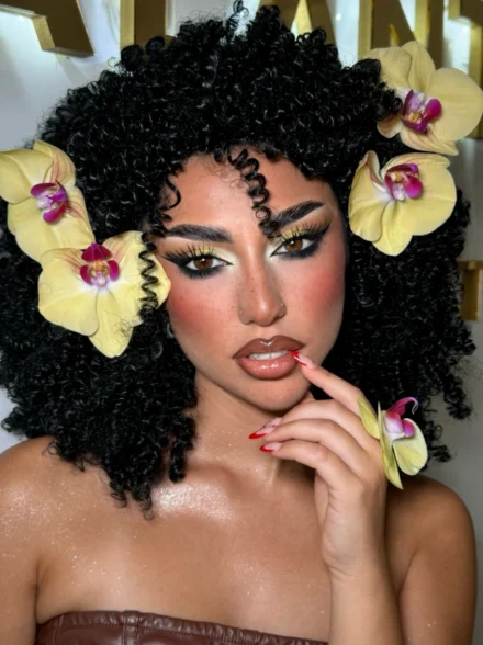 Creative floral-inspired makeup on curly hair model by Anna Balantinou